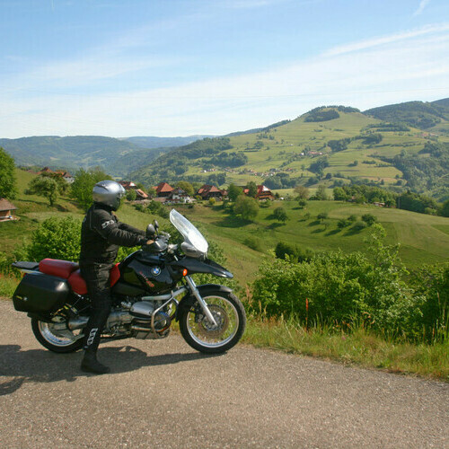 Motorradfahrer geniet sitzend auf dem Motorrad die Aussicht 