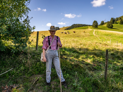 Auf dem Foto ist Dorfhirte Otto zu sehen. Im Hintergrund die Berglandschaft von Frhnd sowie einige Hinterwlder Rinder.